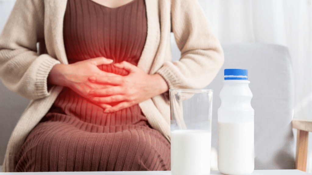 Woman experiencing mild stomach discomfort, representing possible digestive side effects from liver supplements.
