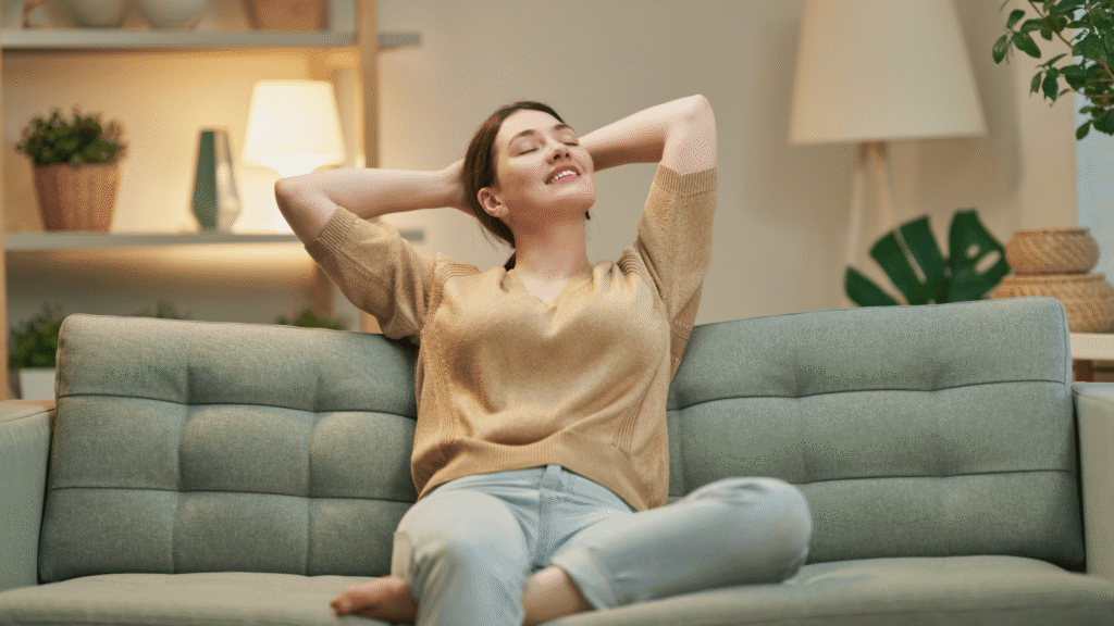 Woman experiencing mild fatigue, a common liver detox symptom, sitting in a relaxed home environment.