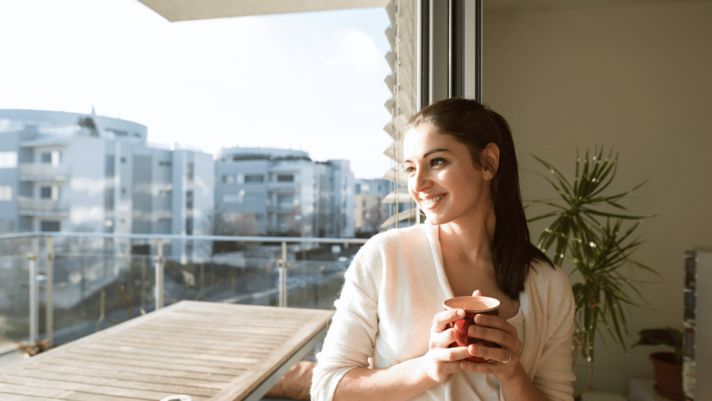 Happy woman enjoying a cup of herbal tea, symbolizing well-being after a gentle liver detox.