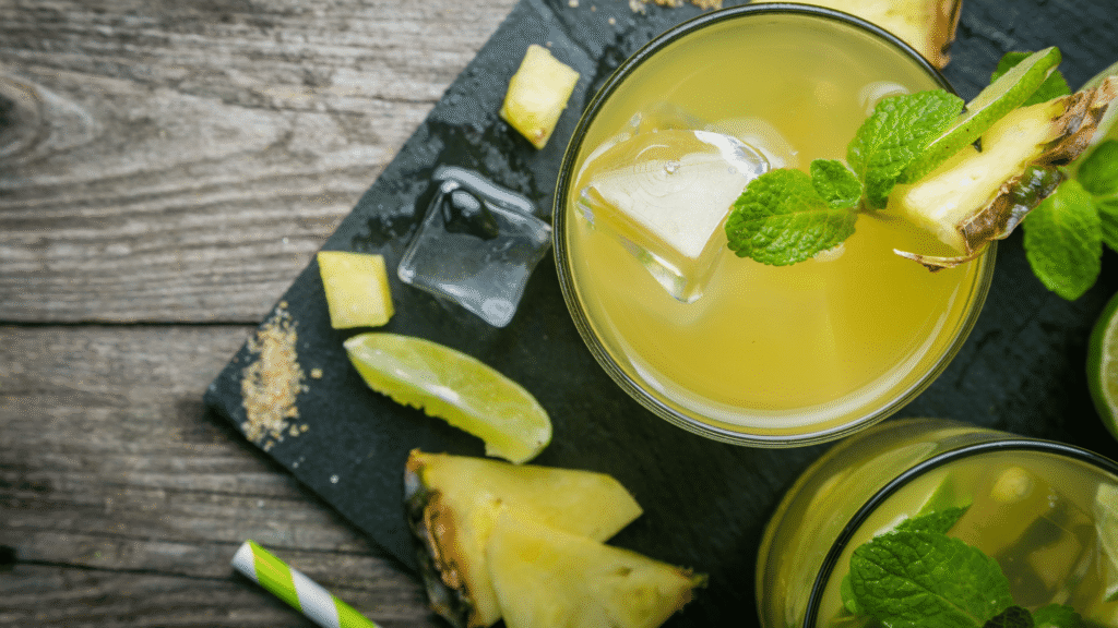 Glass of tropical liver detox juice with pineapple, papaya, lime, and mint